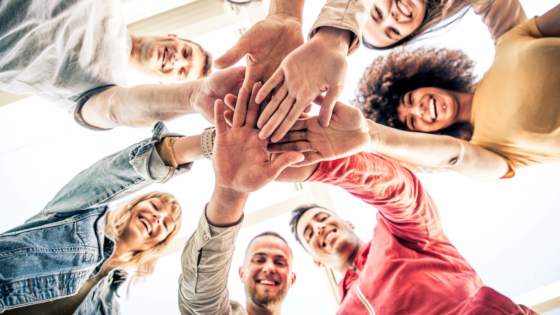 group of people putting their hands to gather in a circle