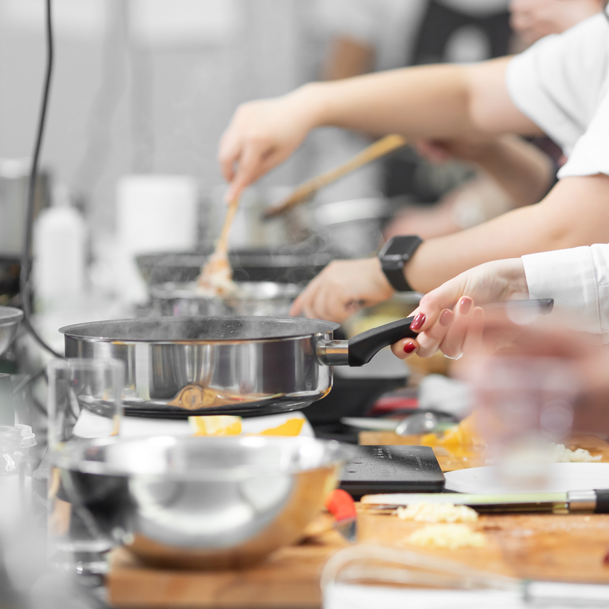 Background cook leads master class in cooking in kitchen