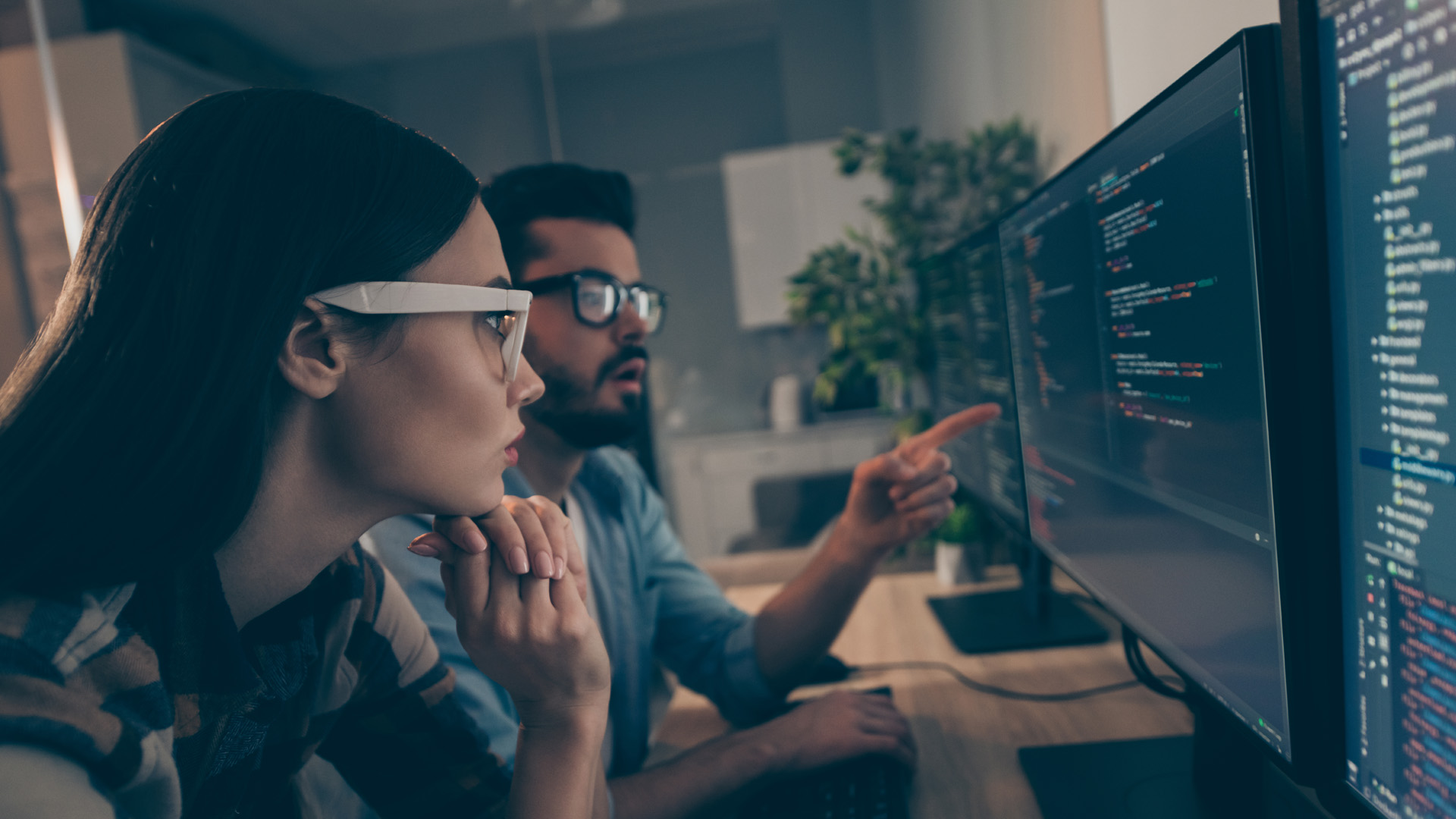 two coworkers watching together indicate monitor testing debugging java script code