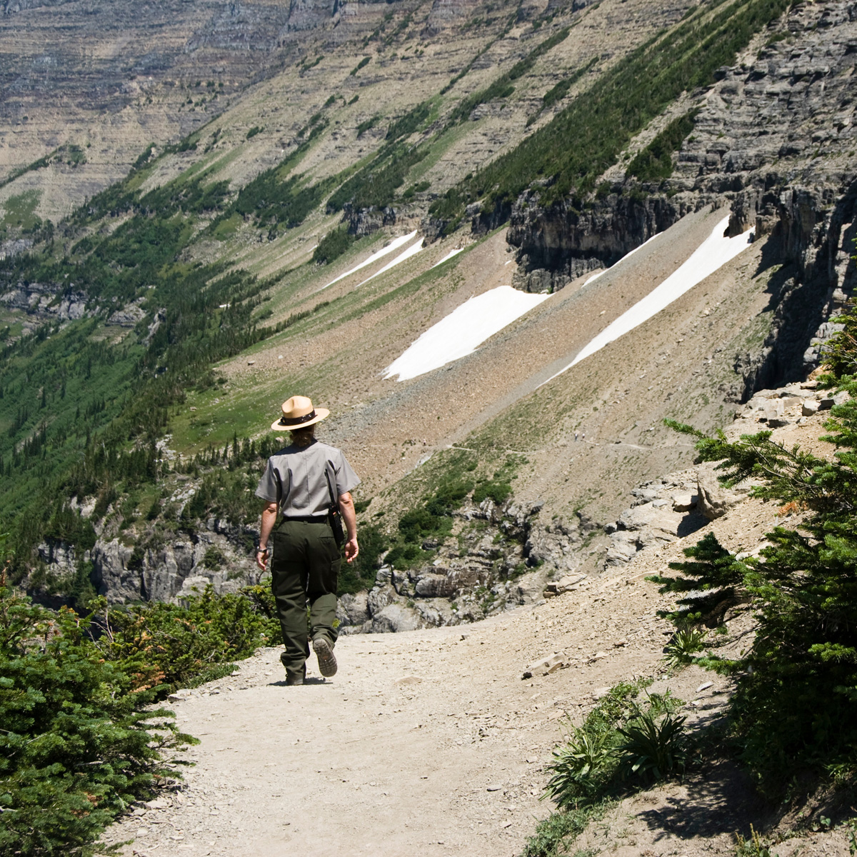 a park ranger walking on Highline Trail in Glacier National Park