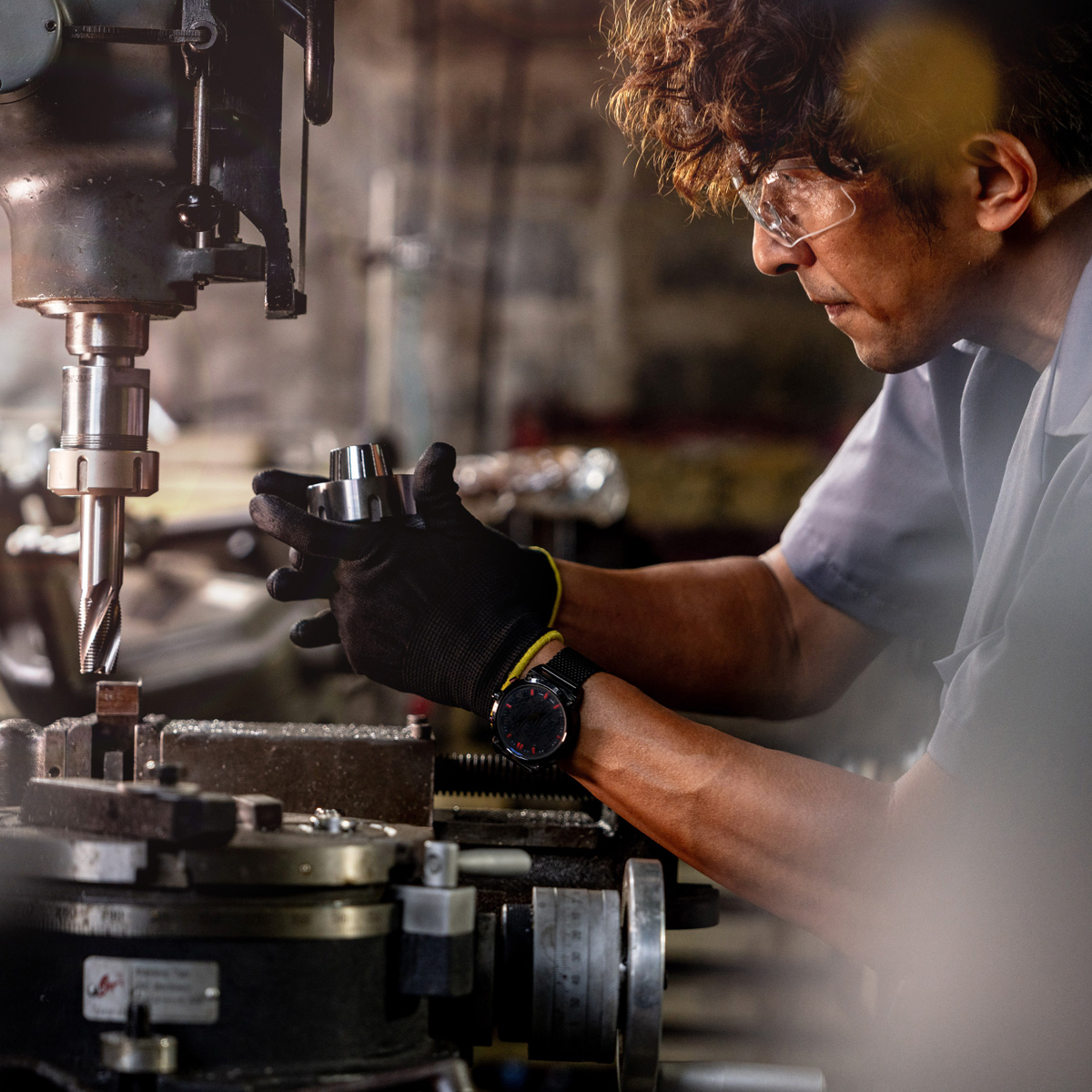 worker in production plant drilling at machine