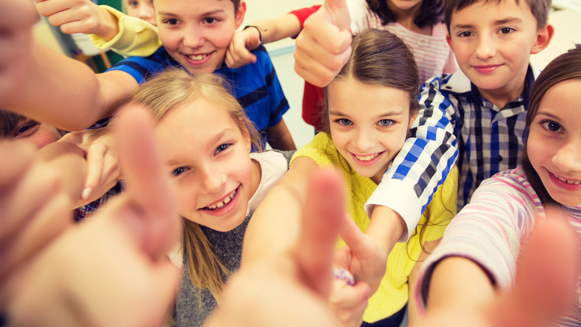 group of school kids showing thumbs up