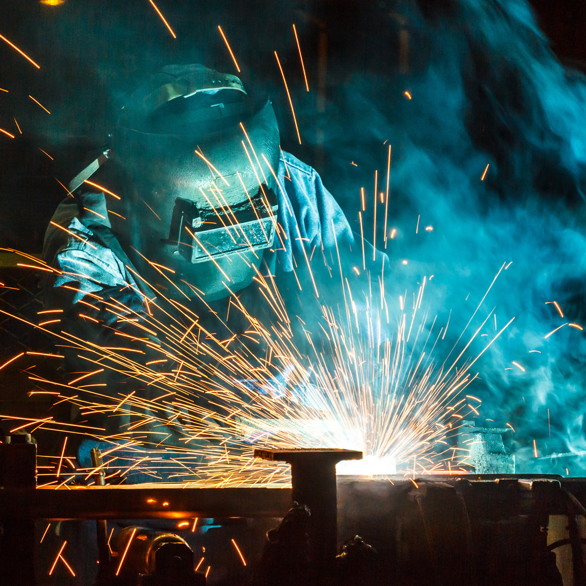 Worker, welding in a car factory with sparks, manufacturing, industry