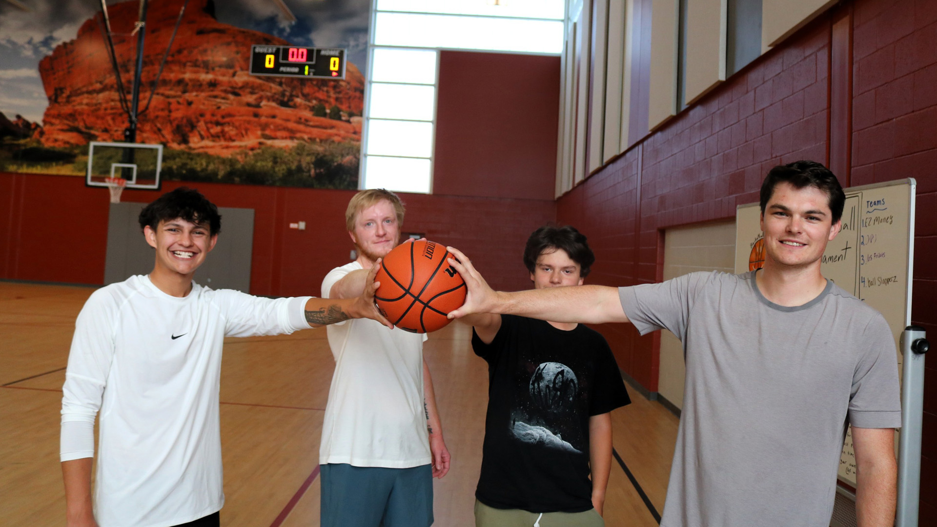 Group of students holding a basketball in the gym