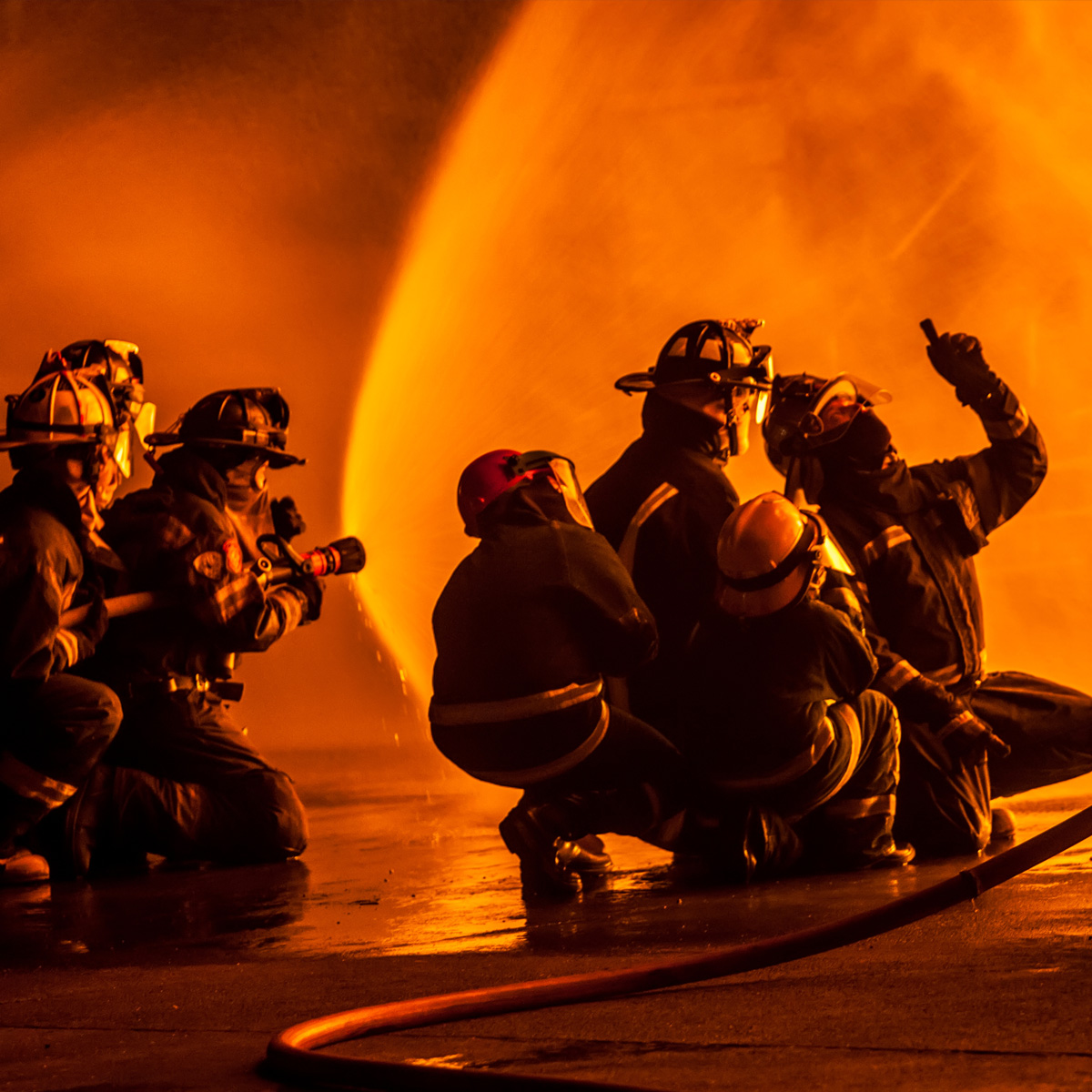 Fire students practicing putting out flames