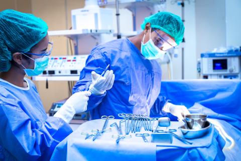 Team of surgeon in uniform perform operation on a patient at cardiac surgery clinic.