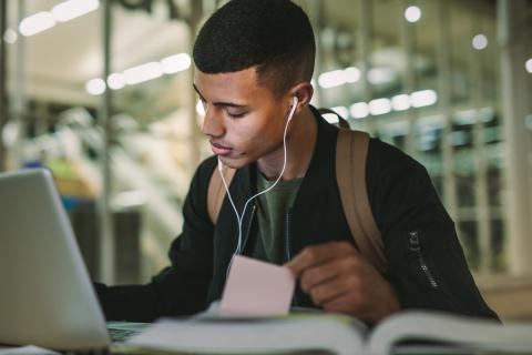Male student listening to music while studying