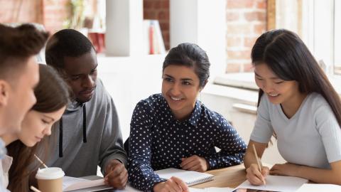 Students gathered around a table talking