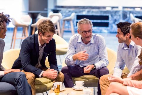 Group of people having a discussion sitting around a table