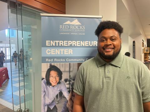 person in. green polo in front of the Entrepreneur Center sign