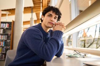 Student in library thinking
