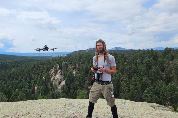 Bradley Harz on a boulder with a drone
