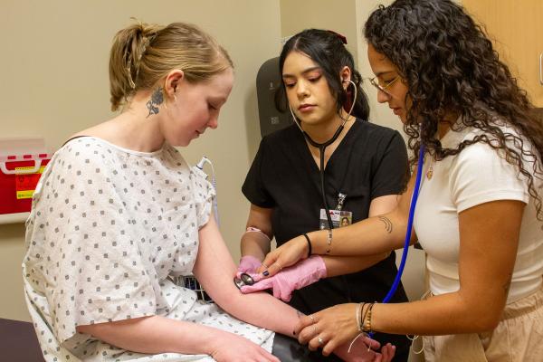 Students checking the pulse on another student 
