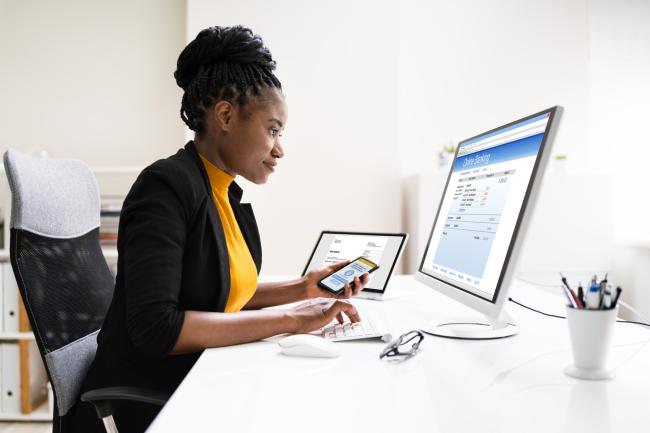 Woman in a black coat using a computer
