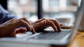 hands typing on a laptop