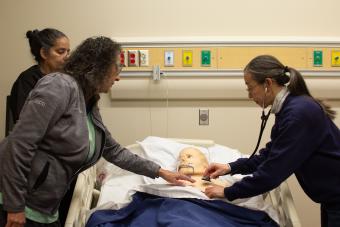 People practicing pulse checks on a mannequin 