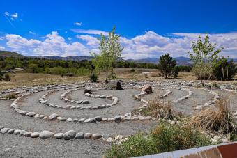 rocks lined up in circle labyrinth with a large rock and tree centered