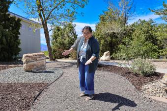 Person poses in a trail with large rocks