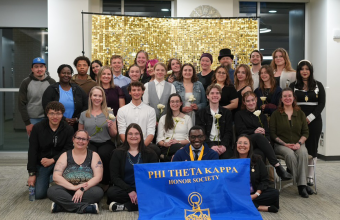 phi theta kappa group with banner