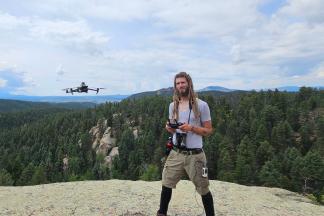 Bradley Harz on a boulder with a drone